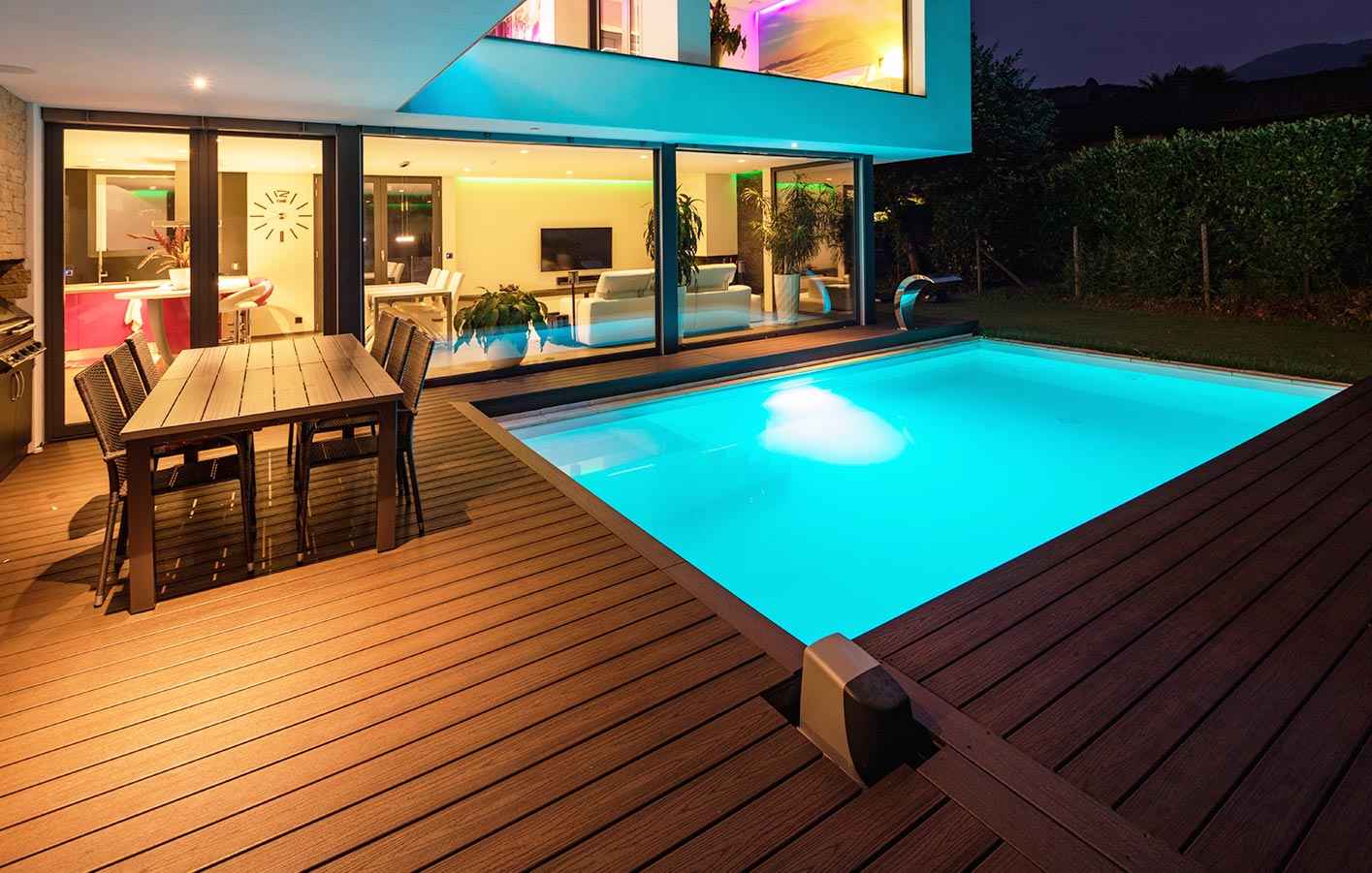 eine große einladende Terrasse mit einem Pool im Dunkeln - beleuchtet