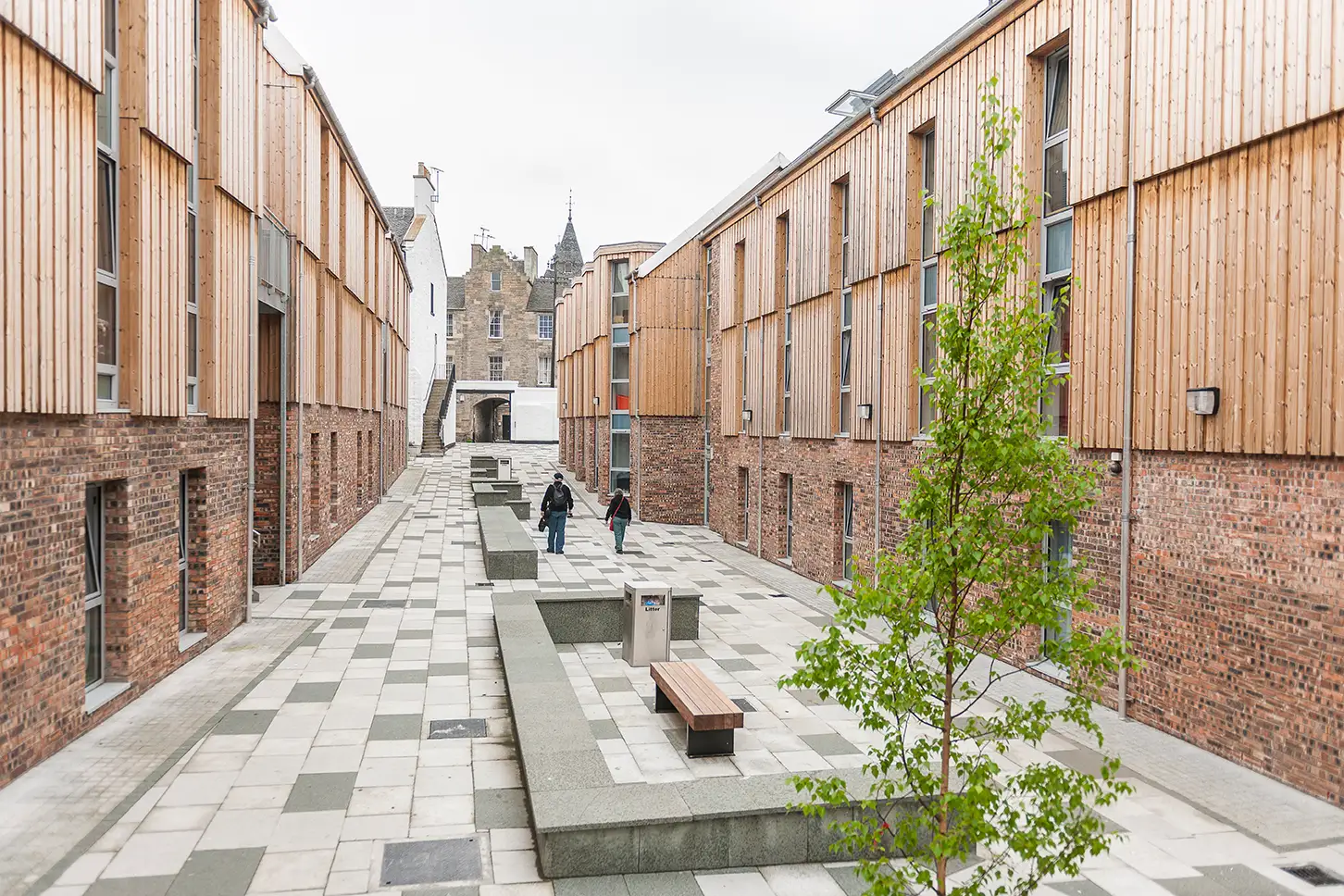 Eine moderne Häuserreihe in einer Stadt mit Holzfassade verkleidet in Bodendeckelschalung